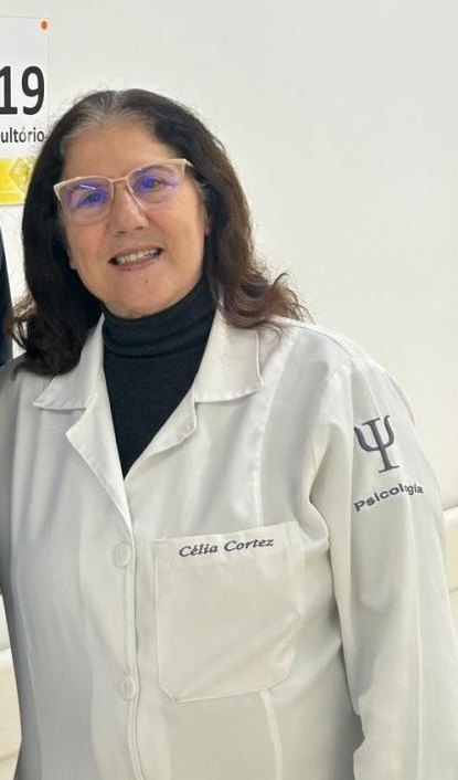 Psicóloga Célia Cortez de jaleco no consultório
